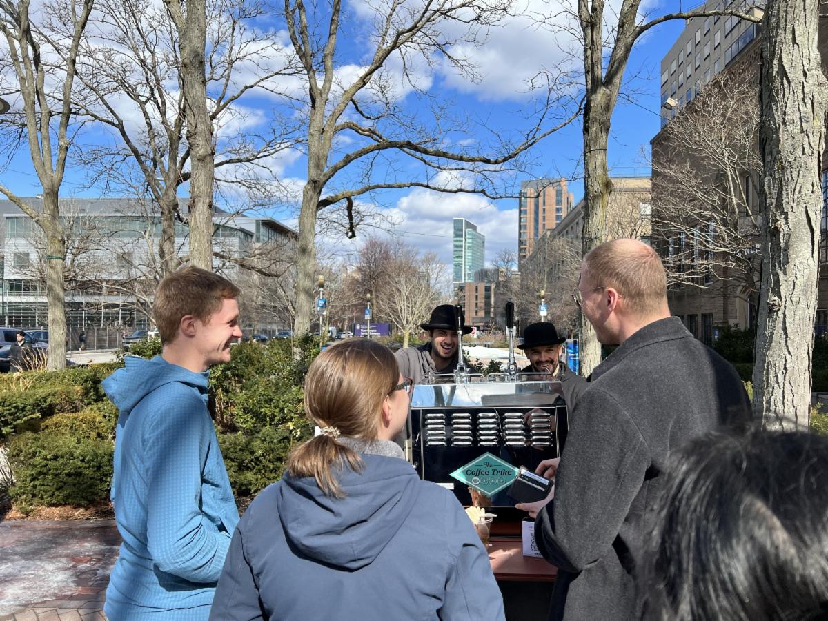 people chat outside of the coffee trike