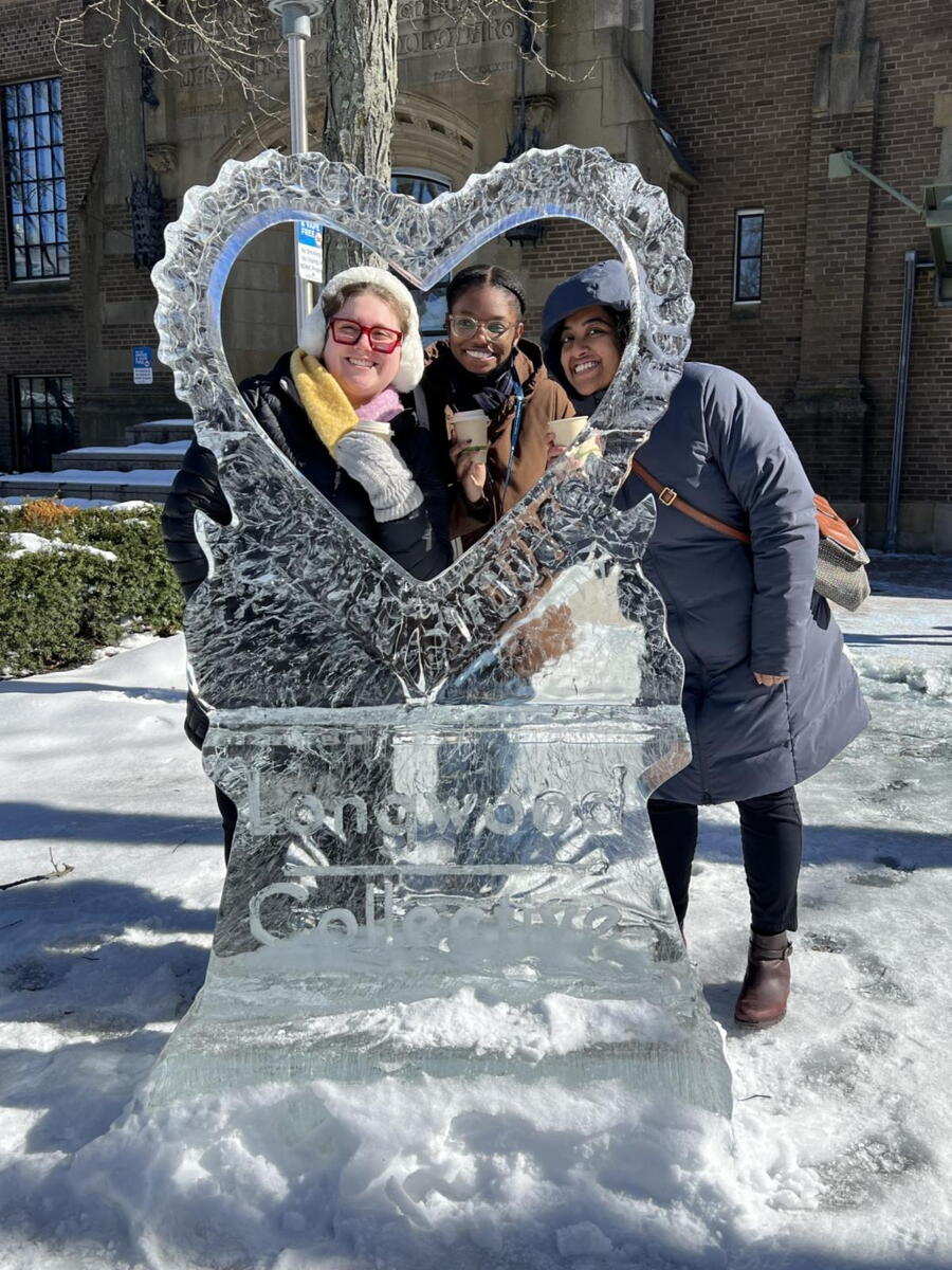 three people pose with heart shaped ice sculpture